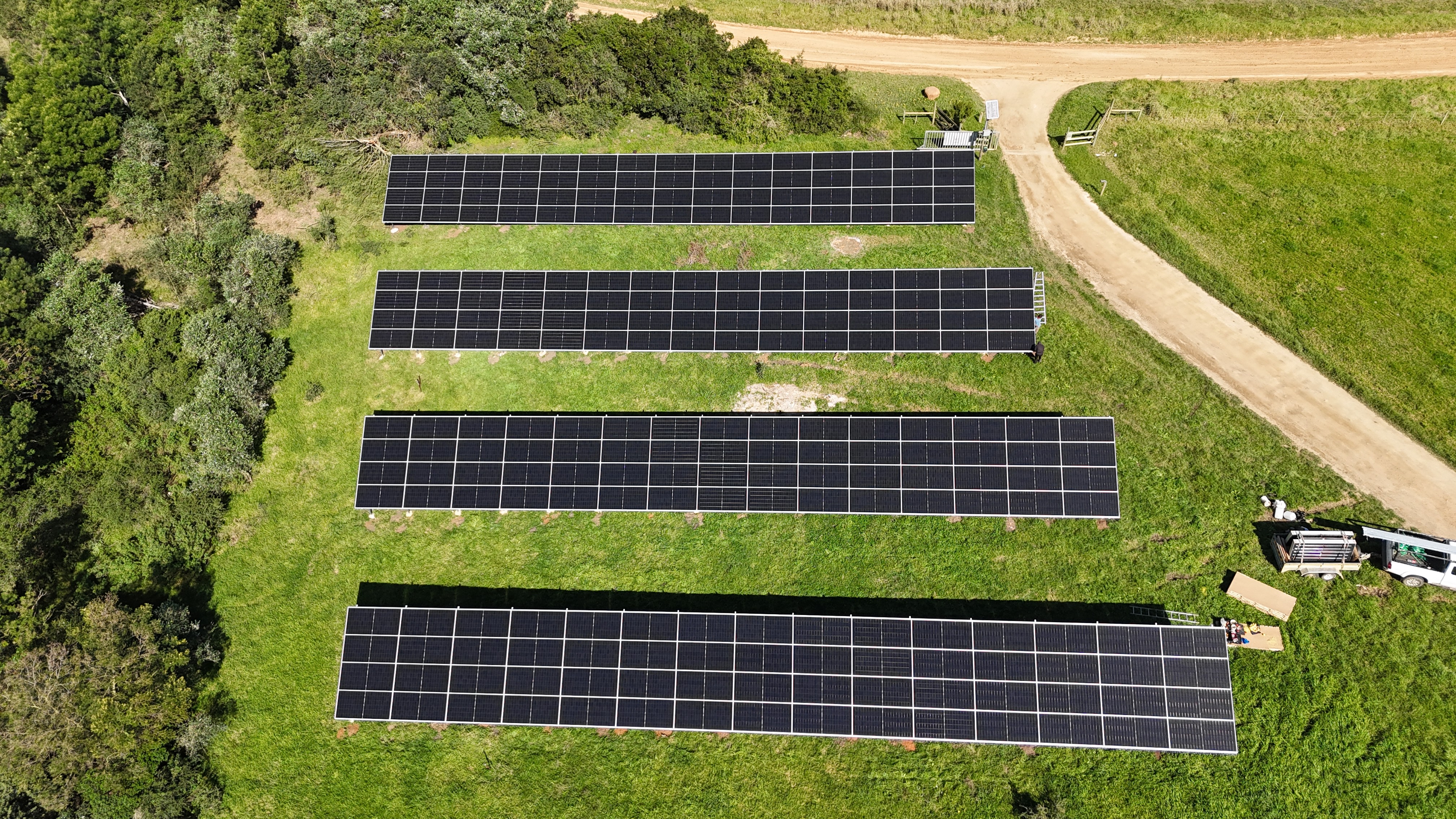 Solar panels on a grassy field under a clear sky.